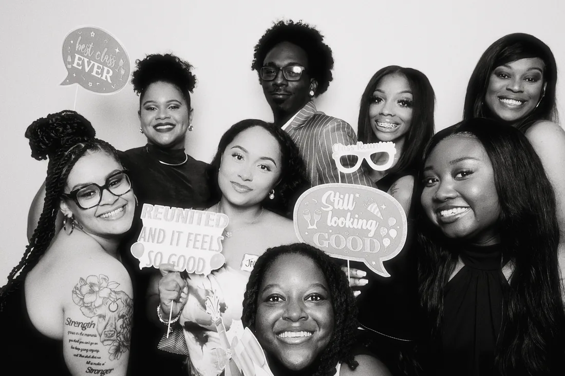 Friends posing with props at a class reunion.