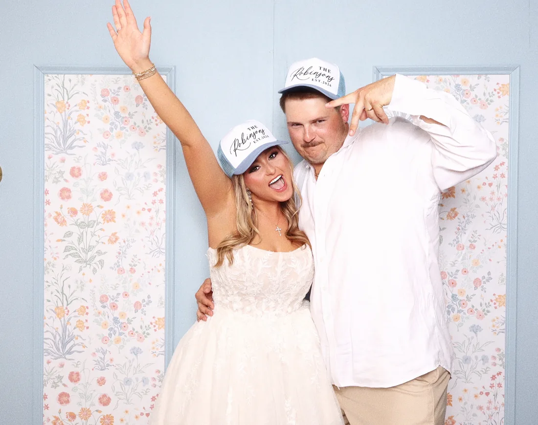 Couple cheering with their arms up in the booth.