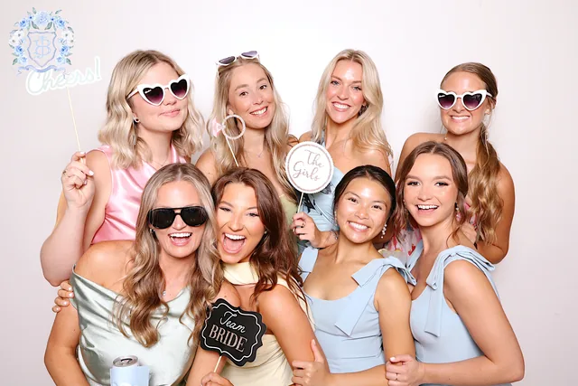 Eight women with Team Bride props, the event's custom overlay in the top corner of the photo.