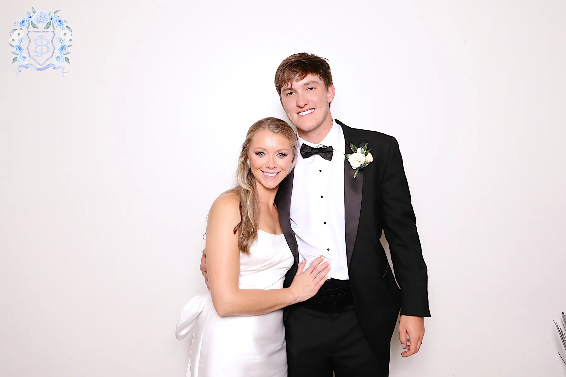 Bride and groom photographed in the open air booth against a clean white backdrop.